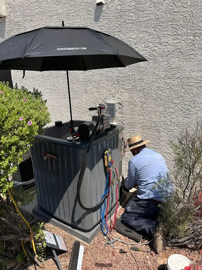 HVAC technician performing outdoor AC maintenance in Wilkinsburg